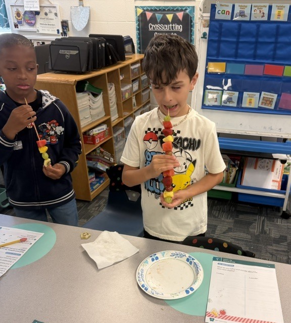 children eating fruit kabobs