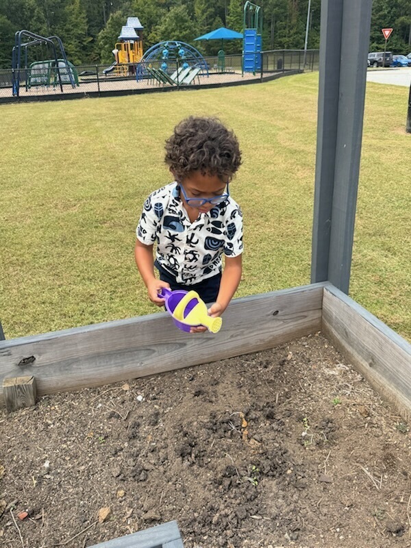 1st grade students planting and watering garden