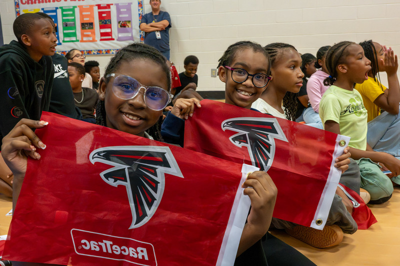 Bright Star Elementary students hold up their Falcons flags during Freddie Falcon's visit.