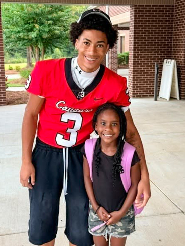 An AHS football player with a student at Mason Creek Elementary.