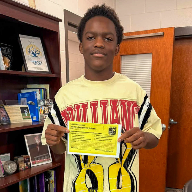 A CHMS student holds up his positive referral card.