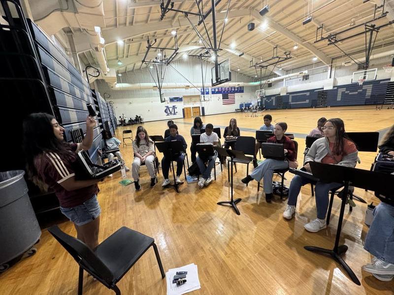 A DCHS student works with MCMS band students
