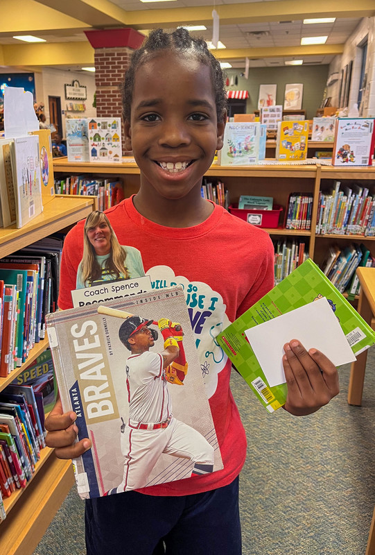 A Chapel Hill student holds up a book.
