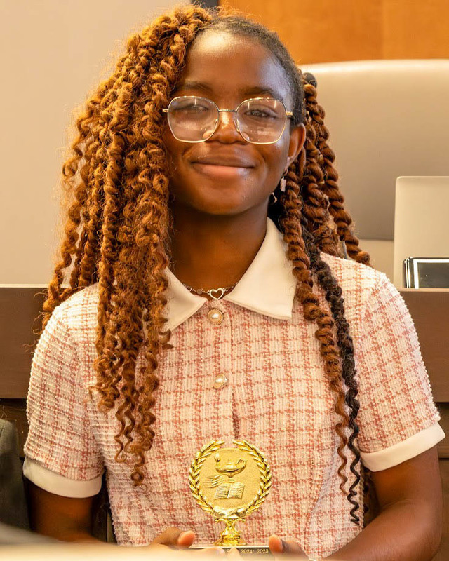 A student who made a perfect score on the GMAS holds her trophy.