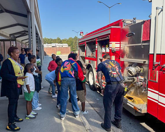 DCSS students with firefighters during a Touch a Truck event.