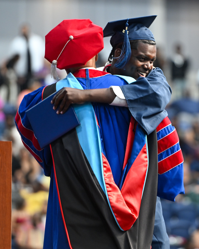 A DCHS graduate hugs Superintendent Dr. Trent North as he crosses the stage with his diploma.