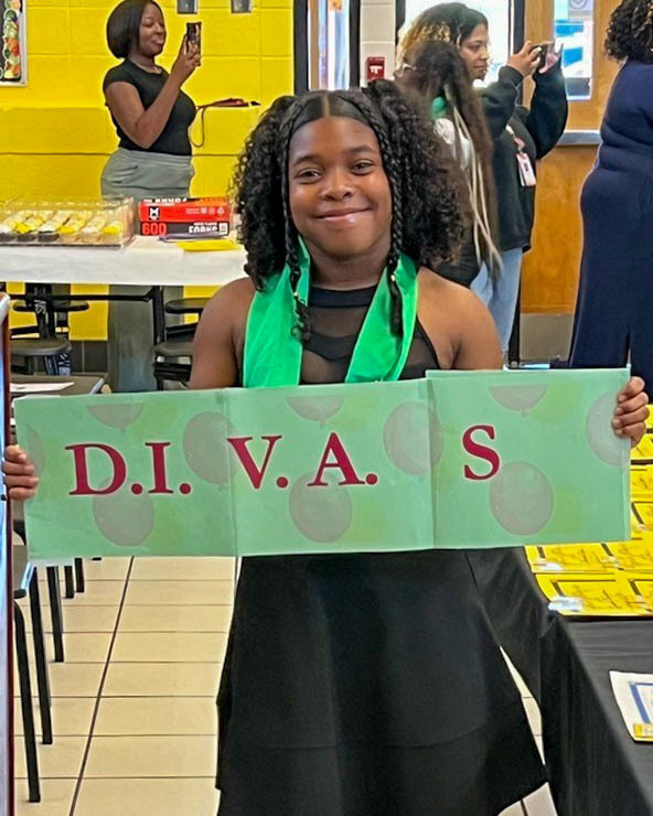 An SMS student holds up a DIVAS sign