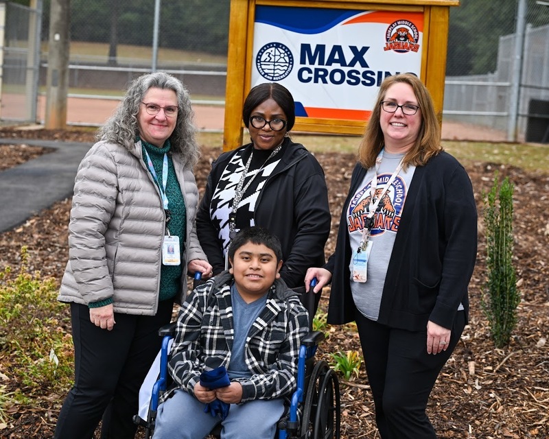 Max's teacher Ashleigh Daniel and other staff with Max Pacheco Ruiz at the ribbon-cutting for Max Crossing.