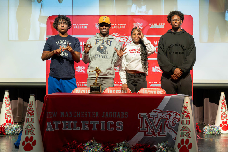 Group photo of Alexander, Guilford, Bussey and DeJesus on signing day at NMHS