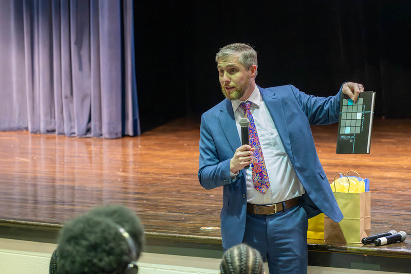 Diplomat Chaz Lott holds up a yearbook from his time at DCHS.