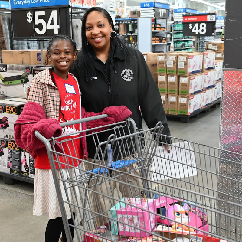 An SRO poses with a student at DCSS Police Shop with a  Cop.
