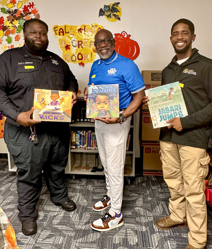 Male role models hold up books they read at Brotherhood through Books at MCES.