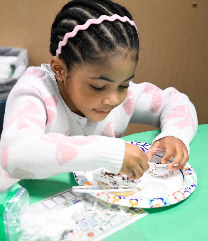 A little girl makes a craft at LEAP Christmas Party