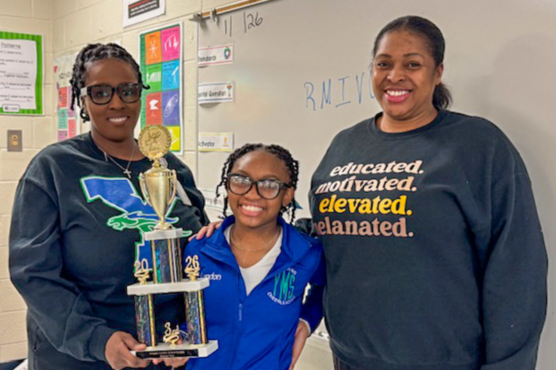 Yeager Middle School third place winner London Moten holds her trophy alongside a school staff member and Principal Tamake Bonner  after placing in the district science fair competition.