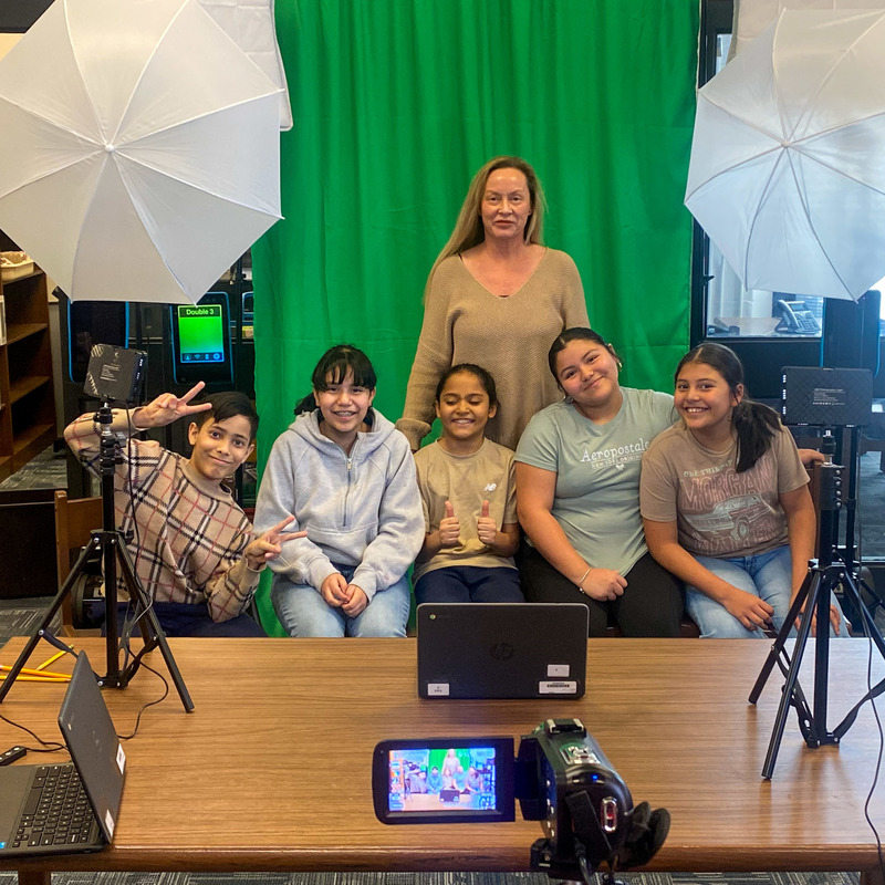 Stewart Media Specialist Heather Deal and five students pose for a photo in front of a green screen.