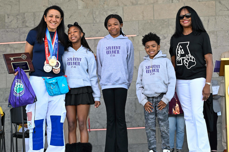Elana Meyers Taylor poses with Arbor Station Principal Dr. Emily Felton and student council members.