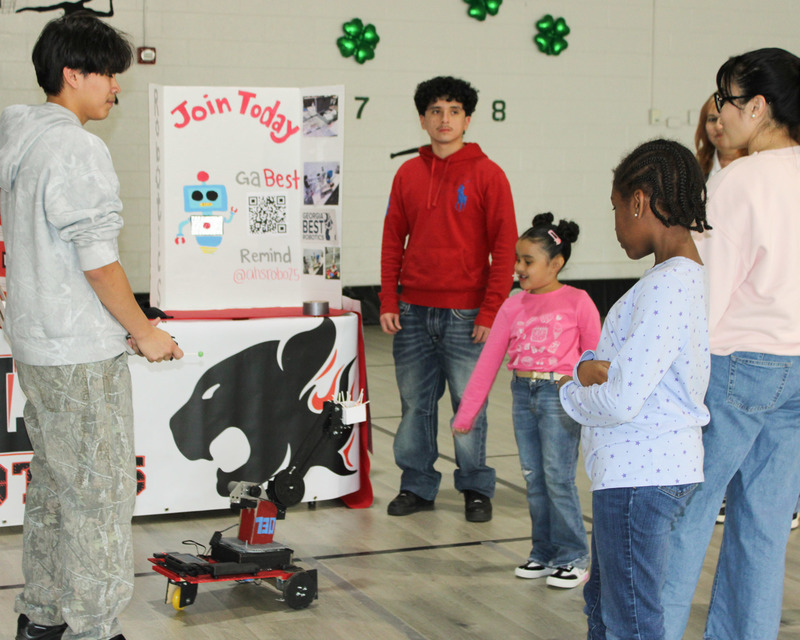 Alexander Robotics Club members display their robot for Mount Carmel students on STEM Night.