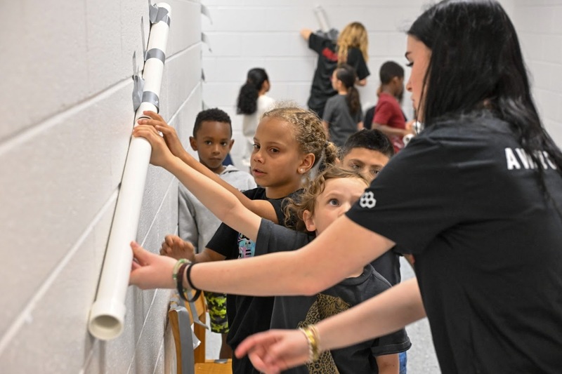 Bill Arp students tape a pipe to a wall as part of a STEAM Day activity.