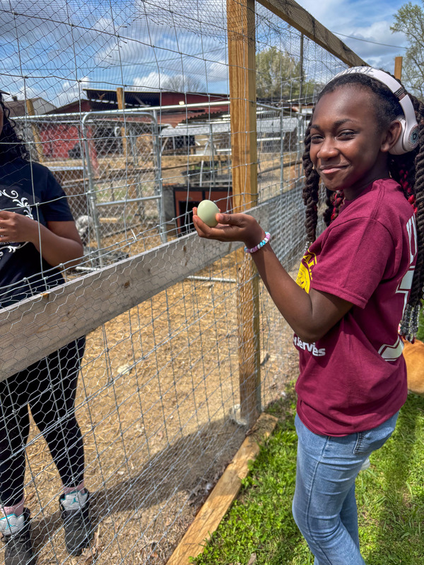 A Factory Shoals Middle student holds up an egg at Swiney Farms.