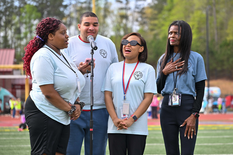 DCSS students sing the National Anthen during the Special Olympics.