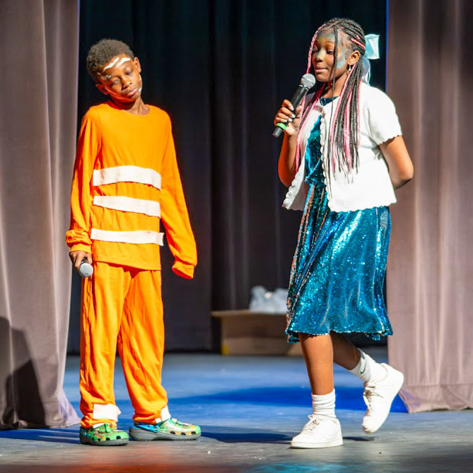 Students wearing Nemo and Dory costumes perform Finding Nemo: Kids.