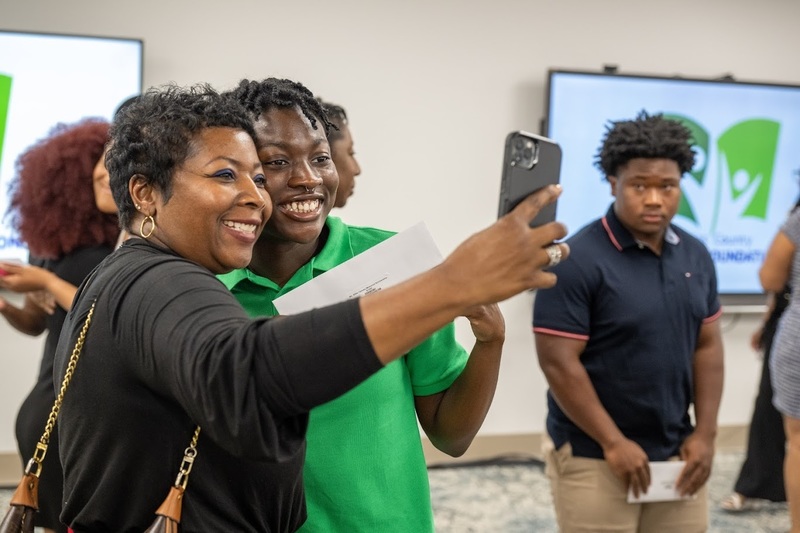 A scholarship winner and his mom take a photo at the DCEF reception.