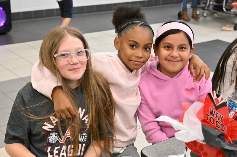 Three Eastside Elementary students pose for a photo in the cafeteria during a special pizza party.