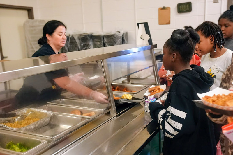 A school nutrition worker serves food to Beulah Elementary students.