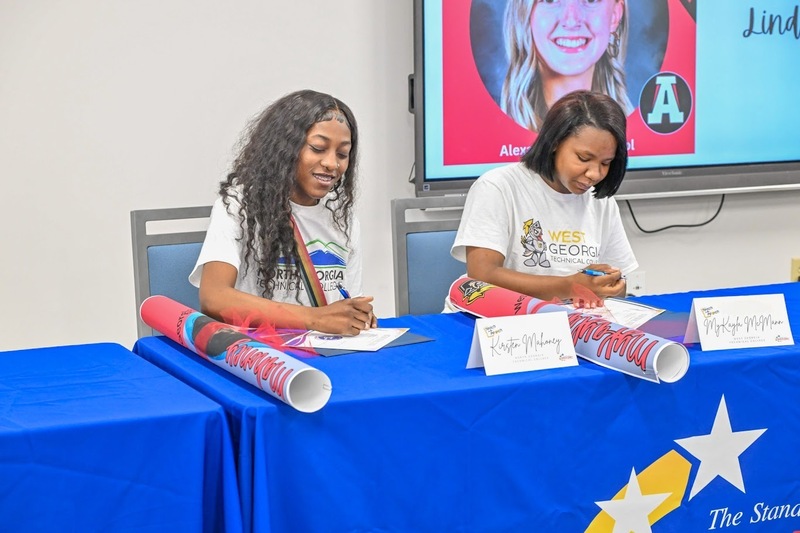 New Manchester students MyKayla McMann and Kirsten Mahoney sign their commitments to pursue education as careers.
