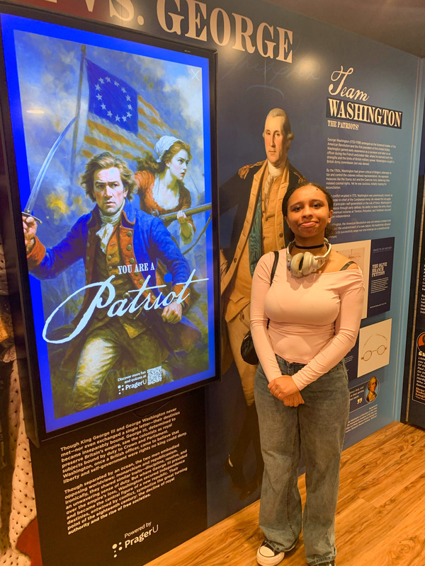 A Douglas County High student poses in front of a "You Are A Patriot" exhibit.