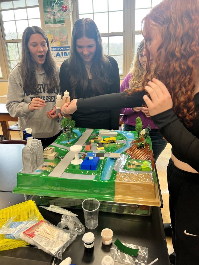 students looking at a plastic model of landscape