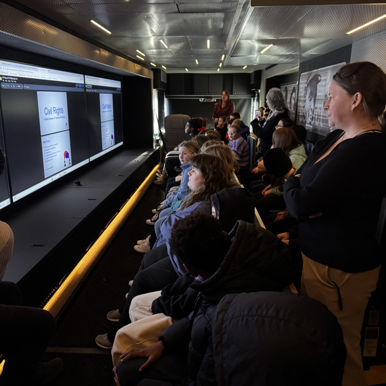 students sitting inside a mobile museum 
