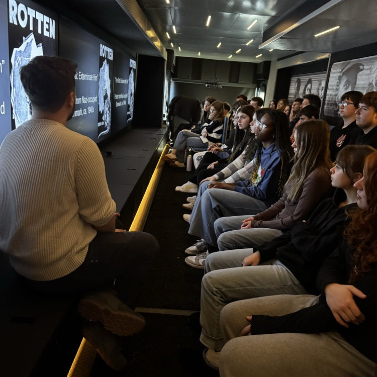 students sitting inside a mobile museum 
