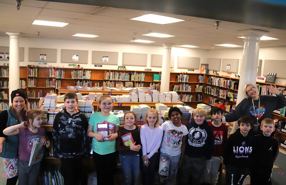 DES students smiling with books donated to the school by Nana's Books Foundation
