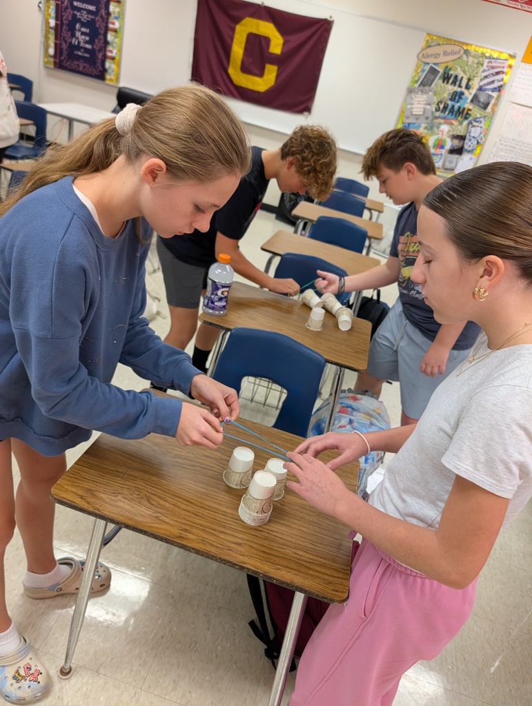 two students making a pyramid of paper cups