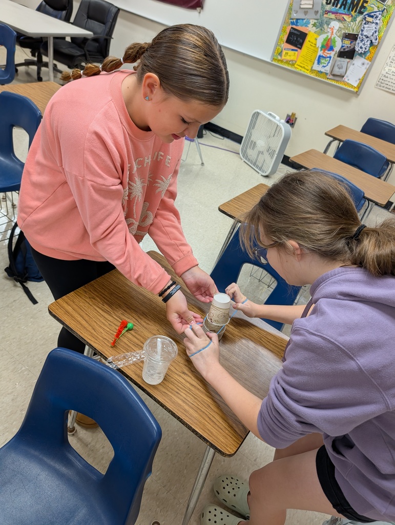 two students making a pyramid of paper cups
