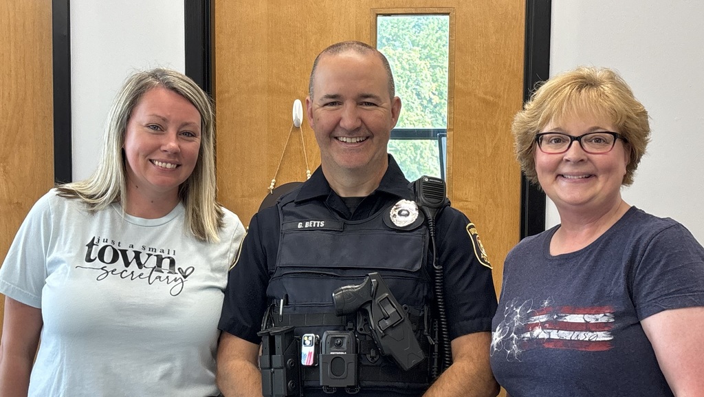 three people standing in a school office