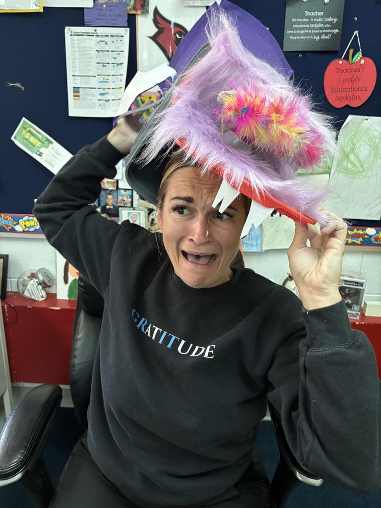 woman putting on a feathery hat