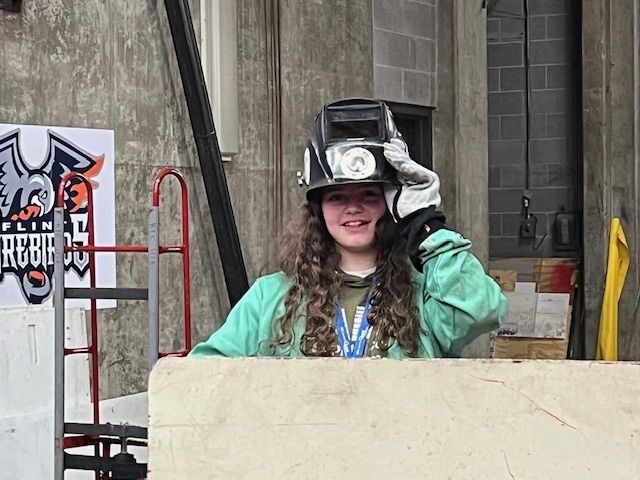 student in welding helmet
