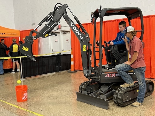 student practicing on an excavator with adult supervision