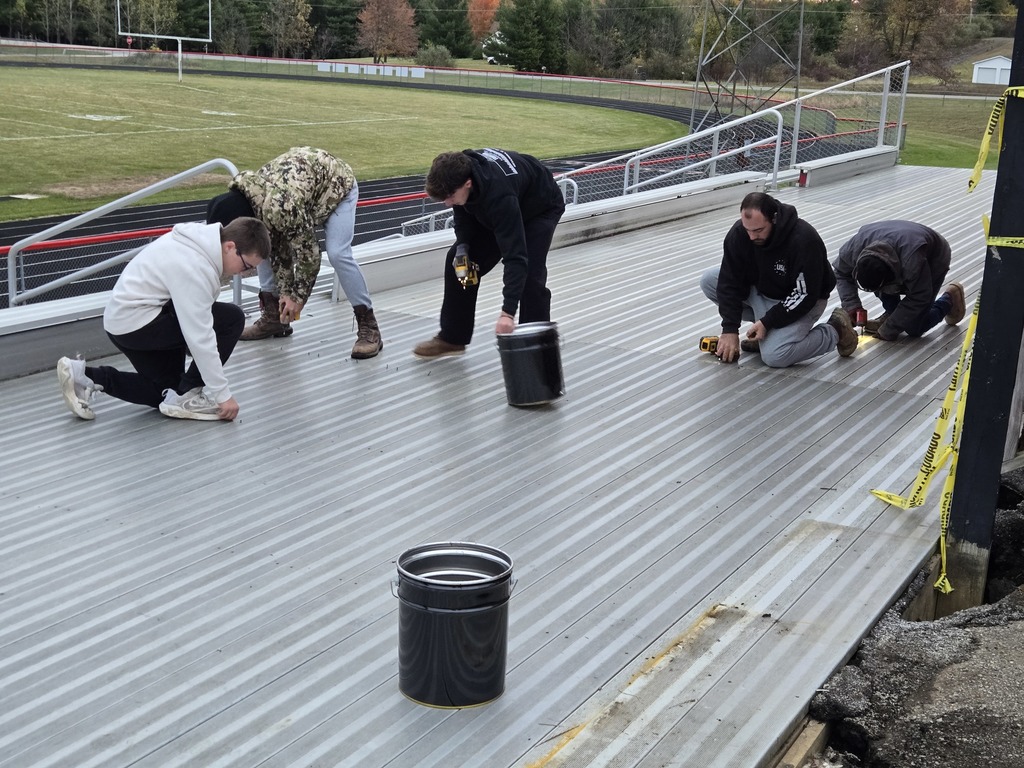 photo of a group of volunteers removing outdoor bleachers