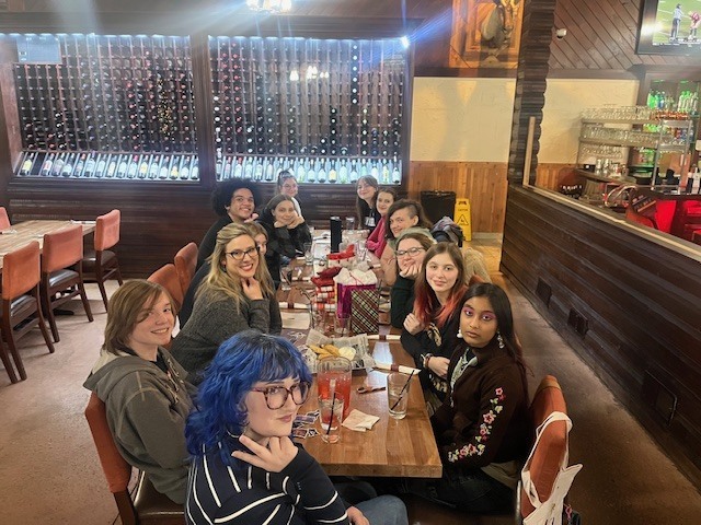 group of high school students sitting at a restaurant table