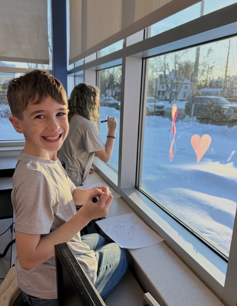 student writign on a window