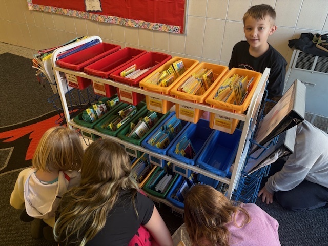 5th grade Student Library Board members helped Mrs. White with the distribution of Friday take-home books for Kdg and 2nd grade. They like to call themselves “book fairies”!