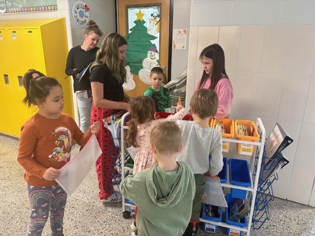 5th grade Student Library Board members helped Mrs. White with the distribution of Friday take-home books for Kdg and 2nd grade. They like to call themselves “book fairies”!