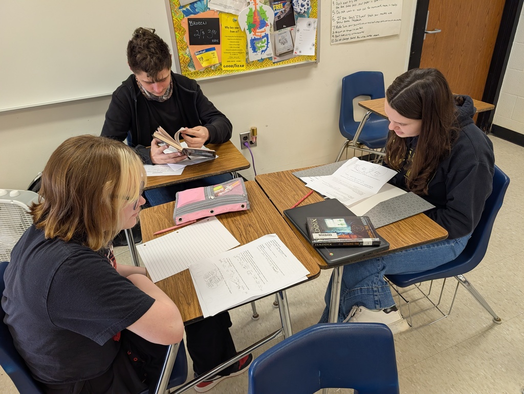 students sitting at desks having a small group discussion