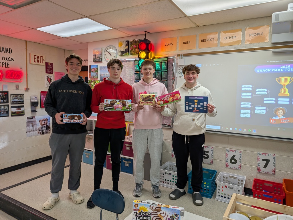 four high school students holding little debbie snack boxes