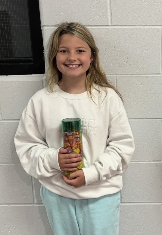 student holding a water bottle filled with candy