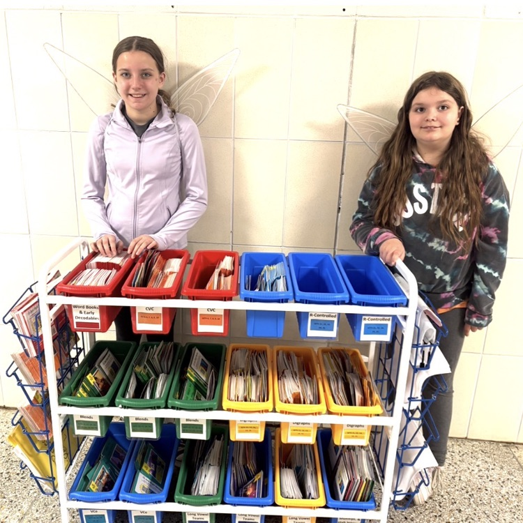 girls in front of a cart of books