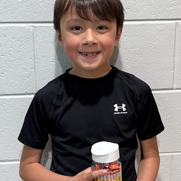 student holding a water bottle filled with pencils